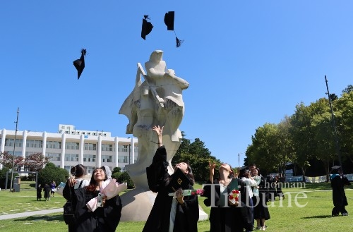 ▲ Graduates throwing their graduation cap in the air after the 2021 second commencement ceremony on August 26 at Bongji Fountain on Gwanjgu campus of Chonnam National University.
