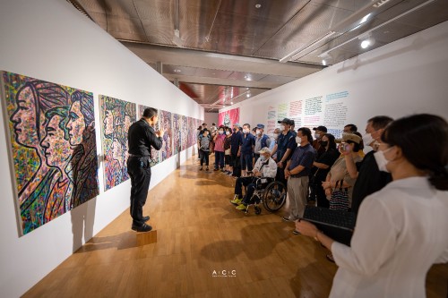 People appreciating artworks at the barrier-free exhibition with a sign language interpreter at Asia Culture Center