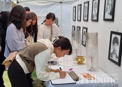 A student writes a tribute in a guest book at the memorial altar for Martyr Park Seung-hee on May 14.