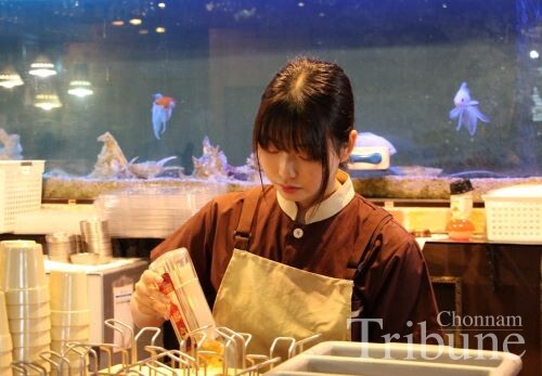 A student laborer works as a server at a restaurant.