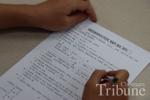 A student laborer signs a contract after confirming his work conditions.