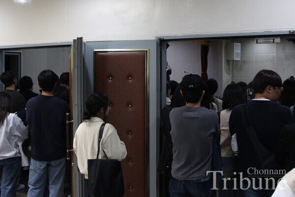 People listen to Profiler Kwon Il-yong's lecture through the open door from outside the lecture hall that is full of audience on November 8.
