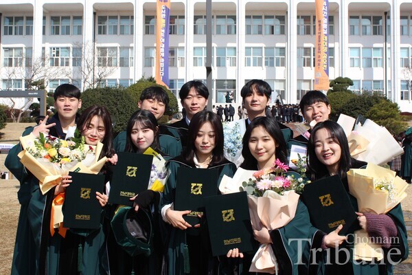 Graduating students pose for a picture in front of Minjumaru after the commencement ceremony on February 26.