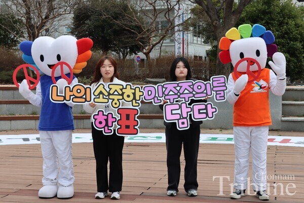 Gwangju Election Commission staff members hold campaign signs to promote voters’ participation in the 22nd general election on March 11.