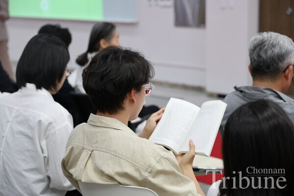 An alumnus reads the book entitled 