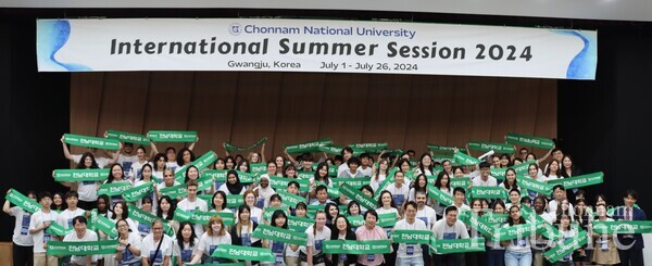Students participating in the CNU ISS 2024 pose for a picture holding a CNU banner together after the opening ceremony on July 1.