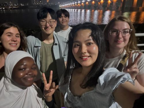 Students pose during a night stroll by the Hangang River