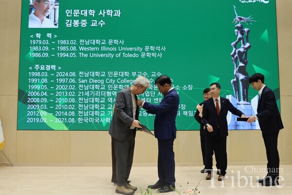 CNU President Jung Sungtaek puts a celebration badge on Kim Bong-joong, a professor of Dept. of History at the ceremony on Aug. 29.