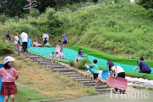 Children enjoy sliding at play zone in Denen Plaza on July 28.
