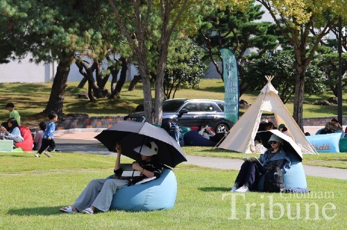 CNU students and residents read books at the outdoor library around Bongji on October 11.