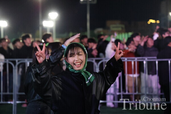A student poses for a picture watching performances on the stage at the festival on Nov. 5.