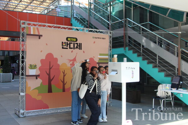 A group of students joyfully take photos at Bandi Festival.