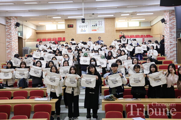 Attendees hold up their Oman Gihaeng bags for a group photo after the ceremony.