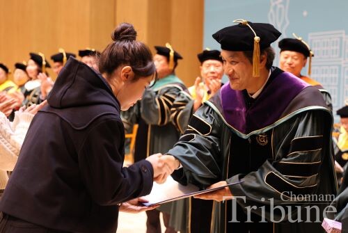 A new student in the Department of Nursing receives a certificate of excellence from CNU’s president during the entrance ceremony.