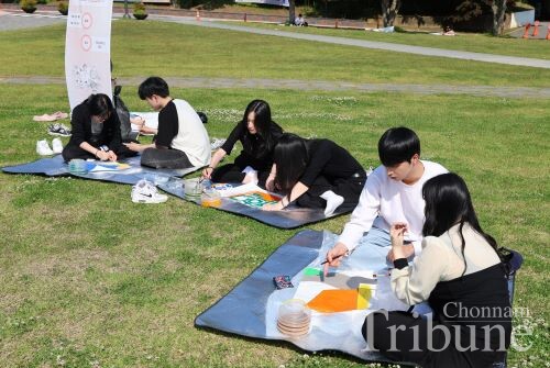 Students paint a section of memorial artwork on May 12.