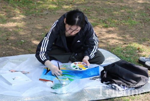 A student paints a section of memorial artwork on May 12.
