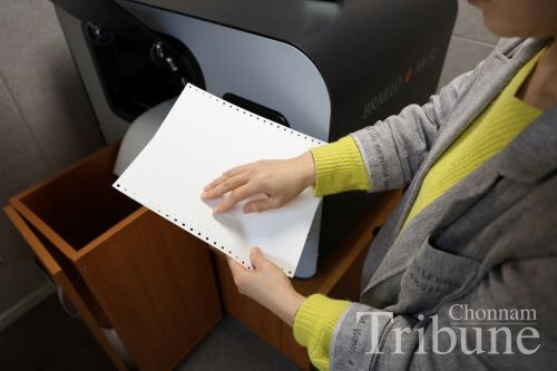 Braille transcriber Kim checks the accuracy of a braille transcription.