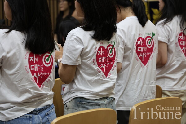 Students wearing t-shirts featuring the campaign's logo