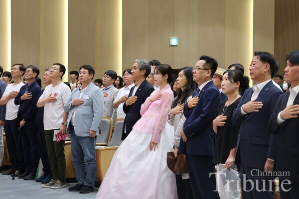 CNU President Lee Keun-bae and key figures from the campaign "Let's Love Our Local Universities" salute the national flag.