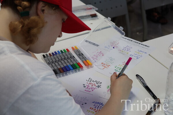 A student is writing calligraphy in the class.