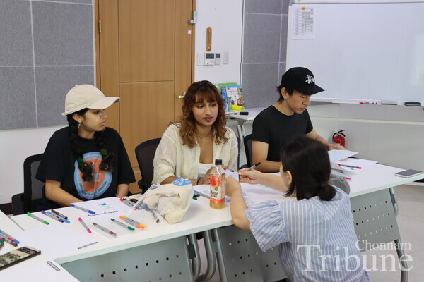 The instructor and students discuss what to write in the calligraphy class.