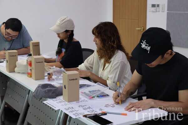 Students stay focused on completing their calligraphy pieces.