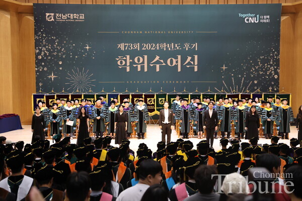 Students and professor from the music education department singing the national anthem.