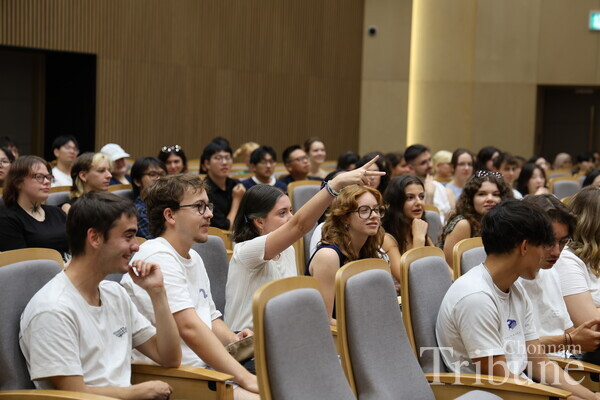 An attendee plays rock-paper-scissors with an orientation host.