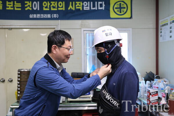 An official from the Gwangju Regional Employment and Labor Office presents a safety helmet to a migrant worker during a ceremony hosted by Samho Concrete Co. on Aug. 22.