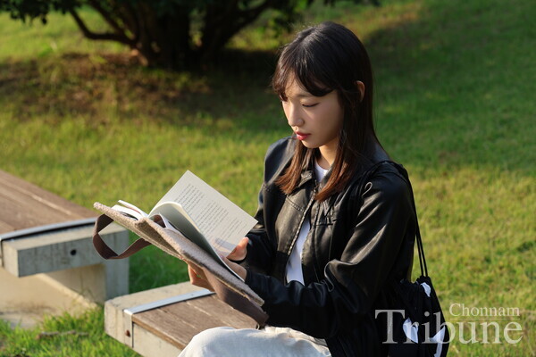 A student reads a book during a recess between classes.