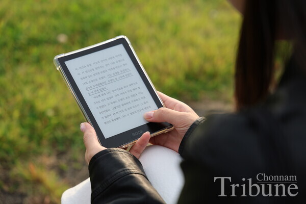 A student reads on an e-book reader during a recess between classes.